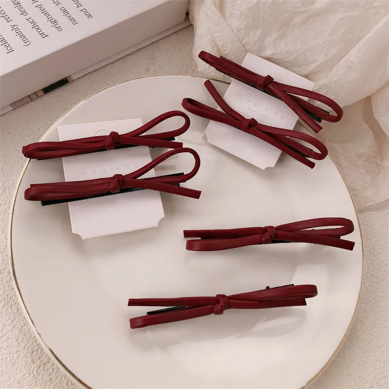 Wine red leather bow barrettes for women with handmade construction and clip mechanism