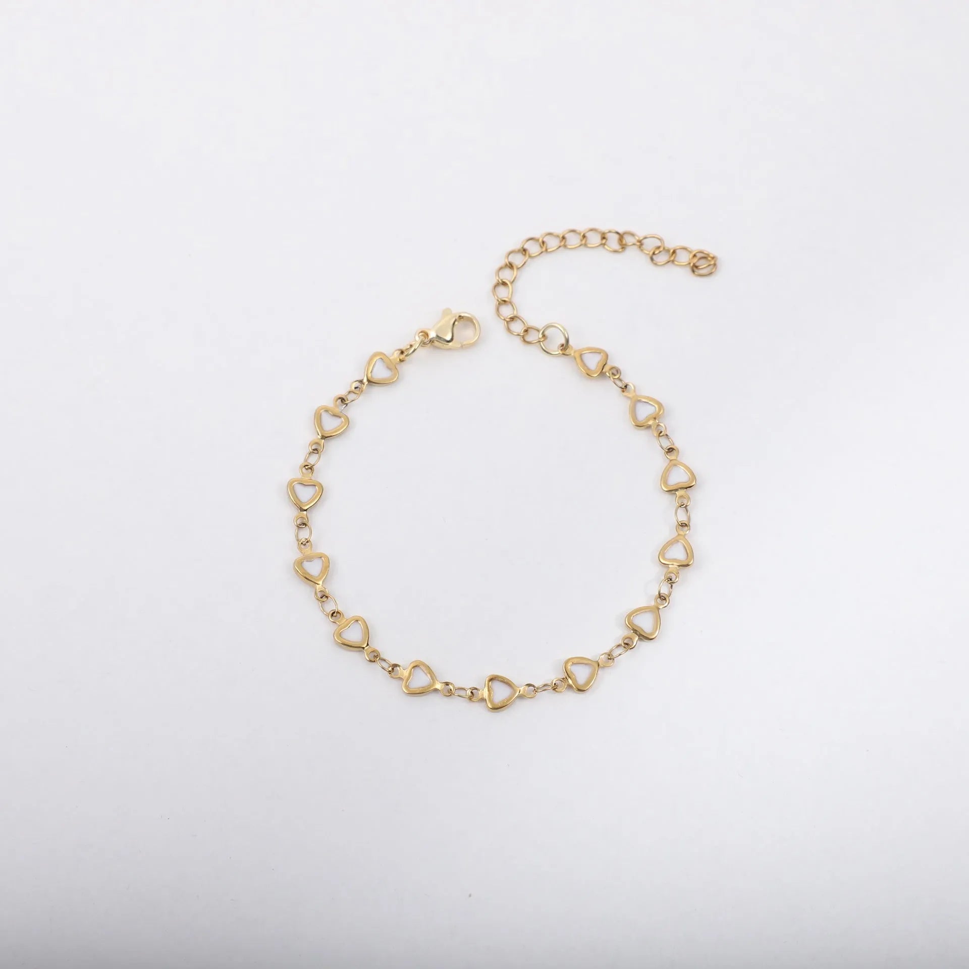 Stainless steel heart-shaped bracelet with gold plating in multiple colour options on a wrist.