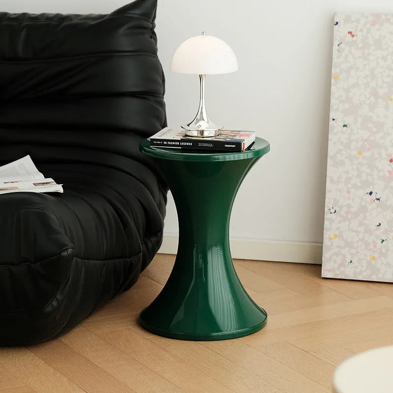Plastic hourglass-shaped shoe changing stool shown in available colours.