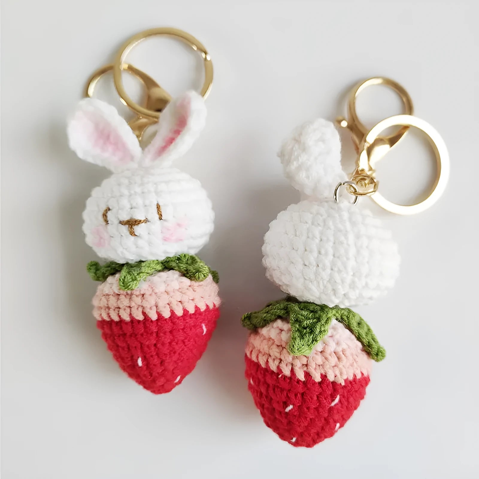 White hand-woven wire pendant with a rabbit strawberry cartoon design and a key loop.