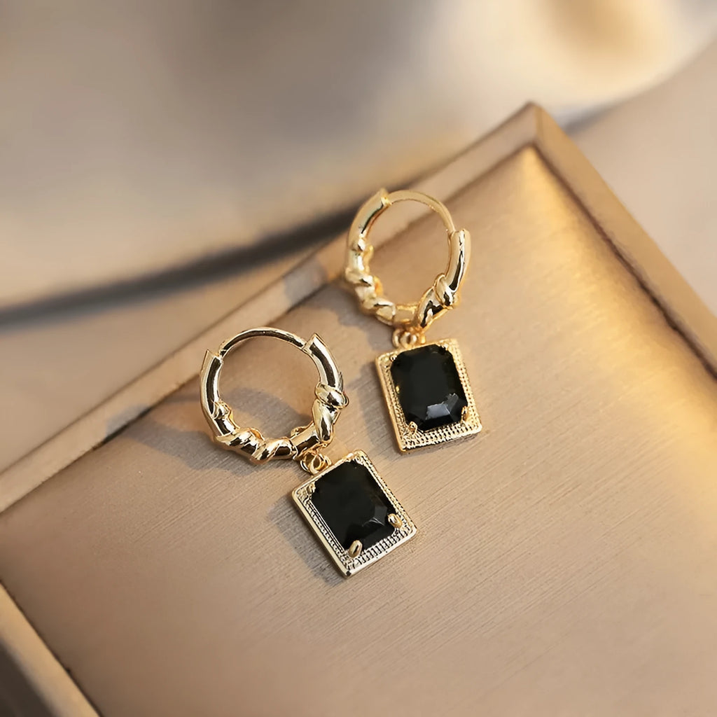 A pair of black geometric quadrilateral earrings with zircon accents on a copper base, retro French court style.