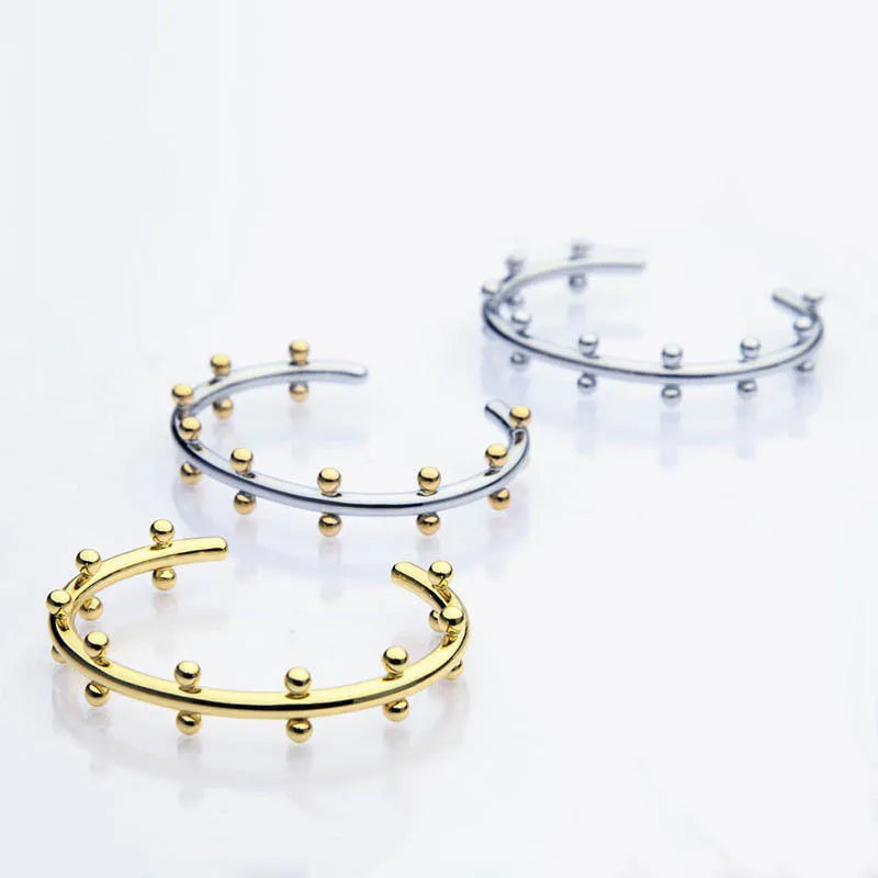 C-shaped textured rivet bean bead charm bracelet in gold, steel, or two-tone finish on an alloy chain.