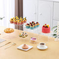 White plastic cube dessert display stand with six individual pieces for cake and confectionery presentation