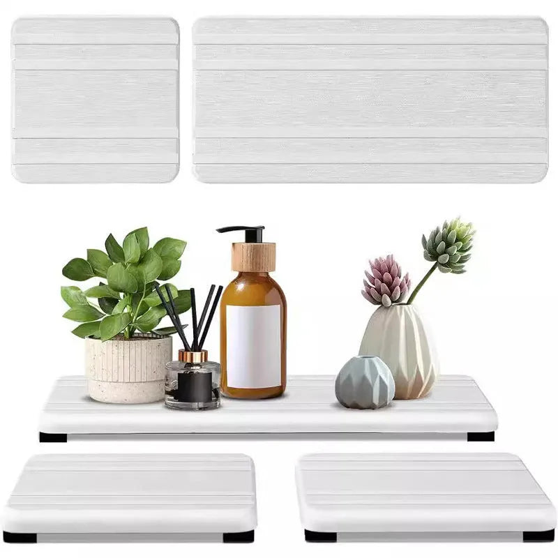 Three square diatomite bathroom draining pads in solid colours on a countertop