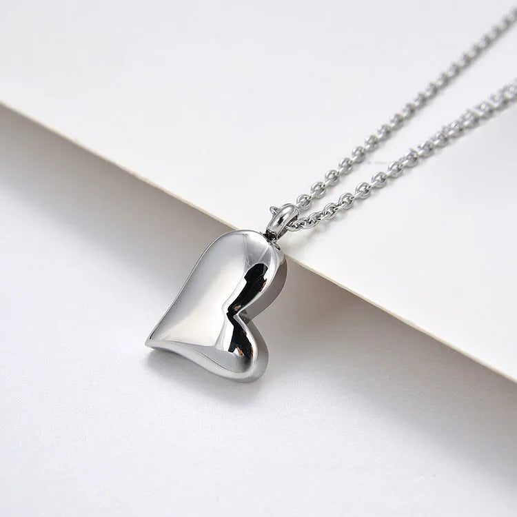 Curved peach heart stainless steel pendant necklace with silver electroplated finish and extension chain
