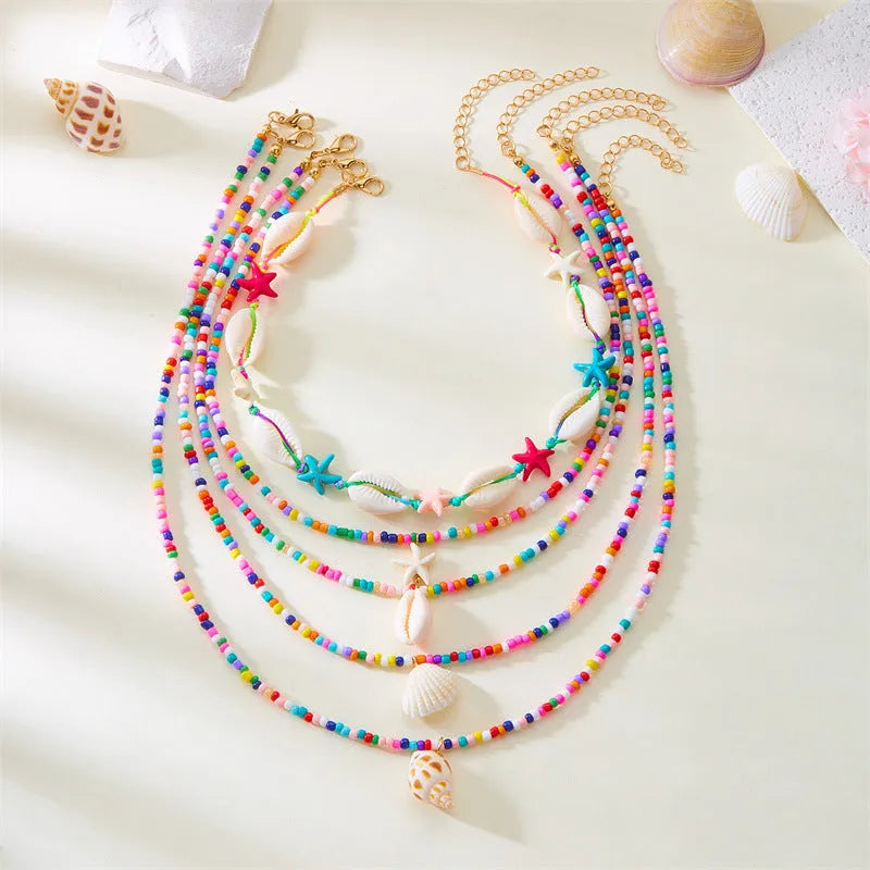 Women's five-layer shell and conch bead necklace set with adjustable chain on blue background