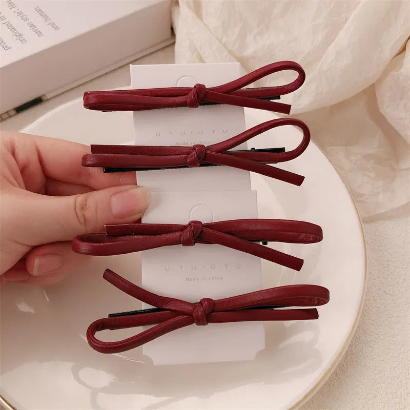 Wine red leather bow barrettes for women with handmade construction and clip mechanism