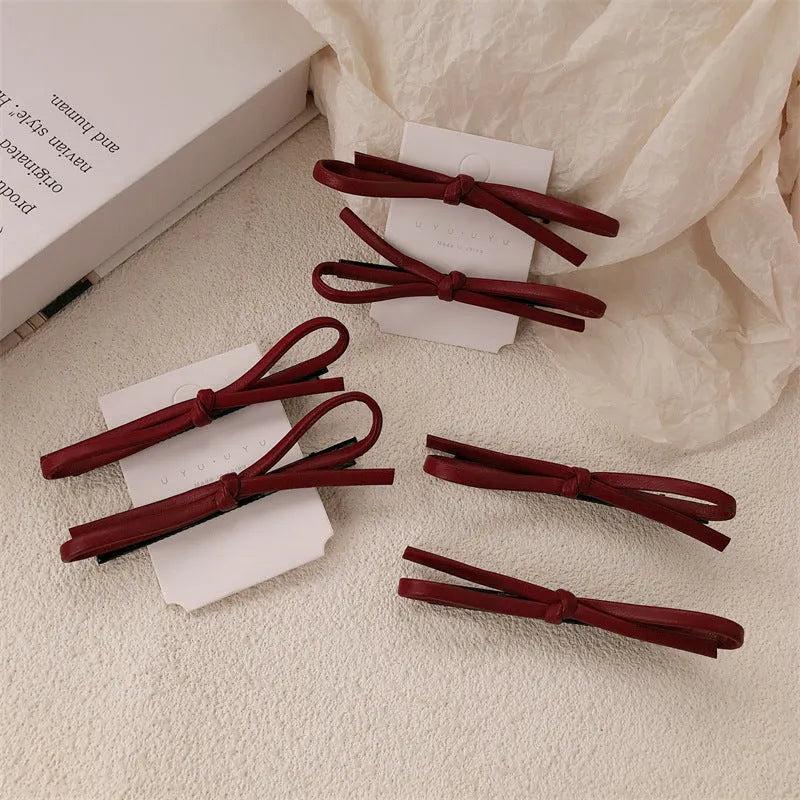 Wine red leather bow barrettes for women with handmade construction and clip mechanism