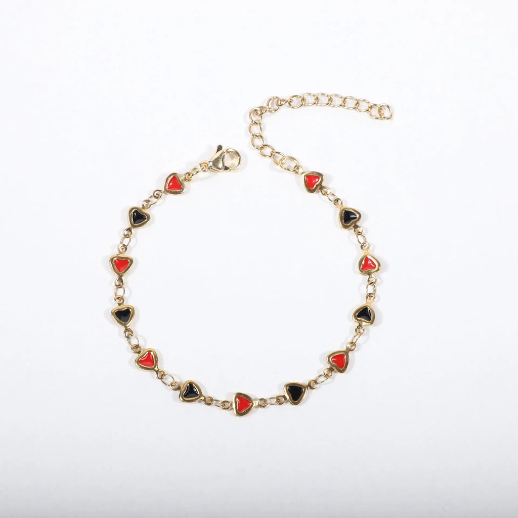 Stainless steel heart-shaped bracelet with gold plating in multiple colour options on a wrist.