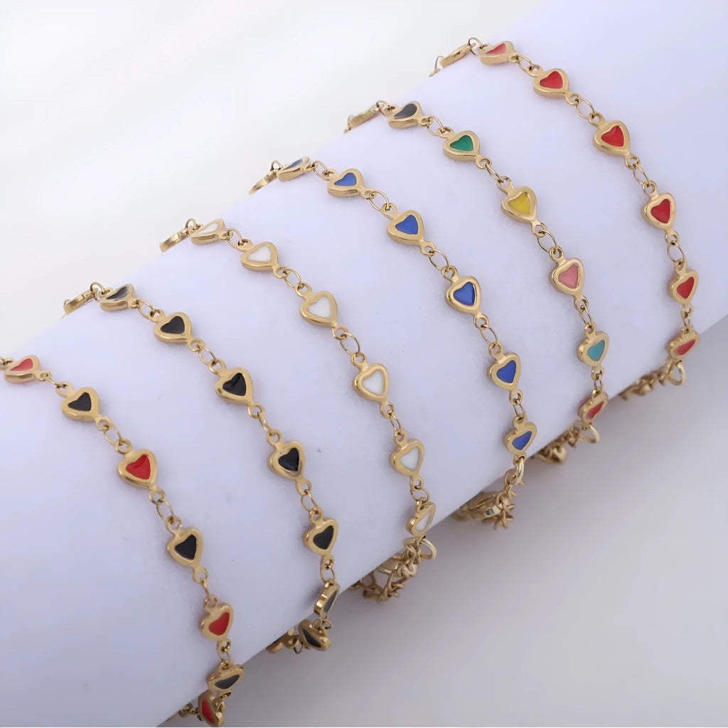 Stainless steel heart-shaped bracelet with gold plating in multiple colour options on a wrist.