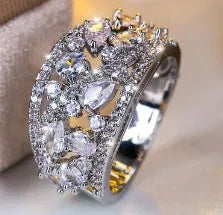 Women's hollow round fashion ring in gold or platinum finish with blue or white accents on a copper band.