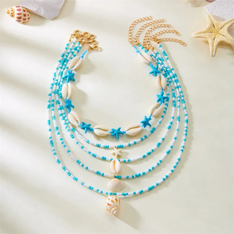Women's five-layer shell and conch bead necklace set with adjustable chain on blue background