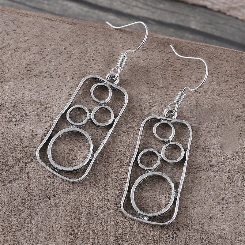 A pair of antique silver round ring earrings with a geometric irregular square design.