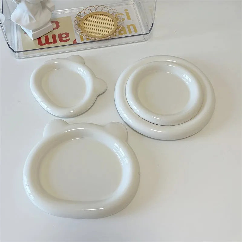 White porcelain round plate with chubby toot bear doodle pattern, shown as a plant saucer.