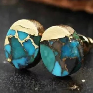 Close-up of handcrafted natural stone bohemian stud earrings with irregular shape on a plain background.