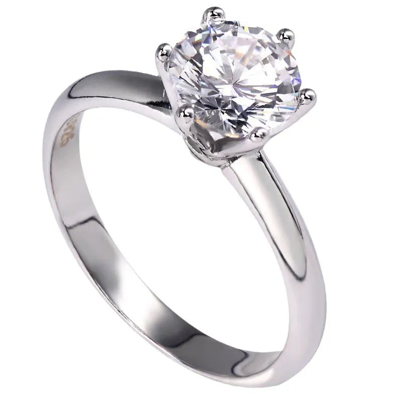 White gold-plated geometric ring with a six-claw setting holding a zircon stone.