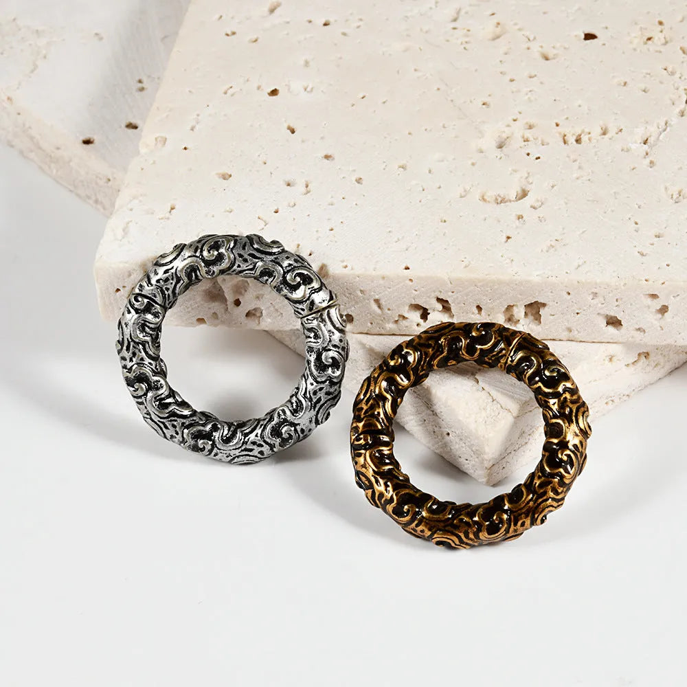 A pair of silver-toned fashion earrings with a geometric totem pattern design on a white background.