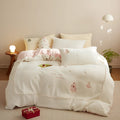 Milk fibre four-piece bed linen set with green Christmas tree pattern on a quilt cover and pillowcase.
