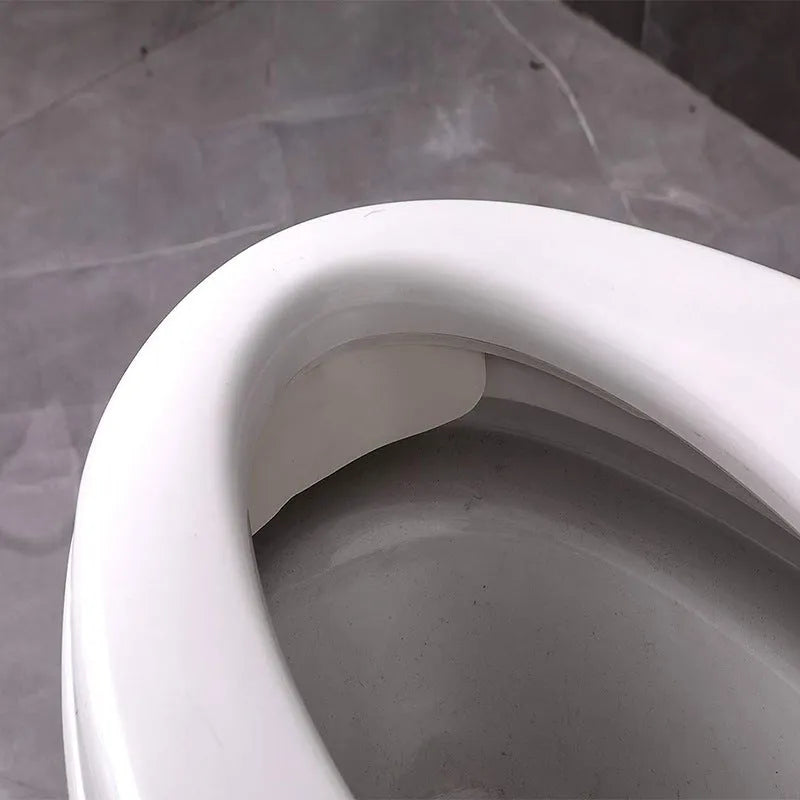 White PVC children's toilet training splash guard placed on a toilet seat.