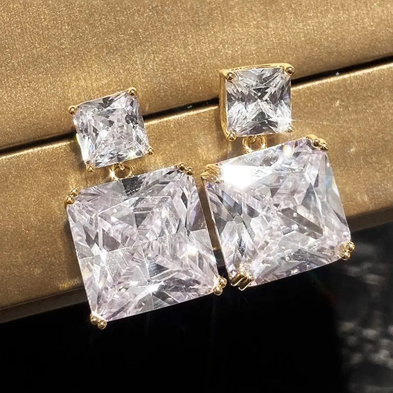 A pair of geometric square design copper earrings for women, shown in white gold and gold colour options.