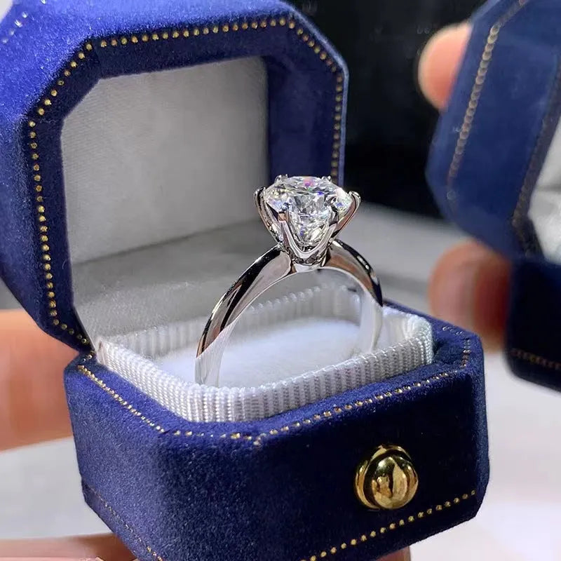 White gold-plated geometric ring with a six-claw setting holding a zircon stone.