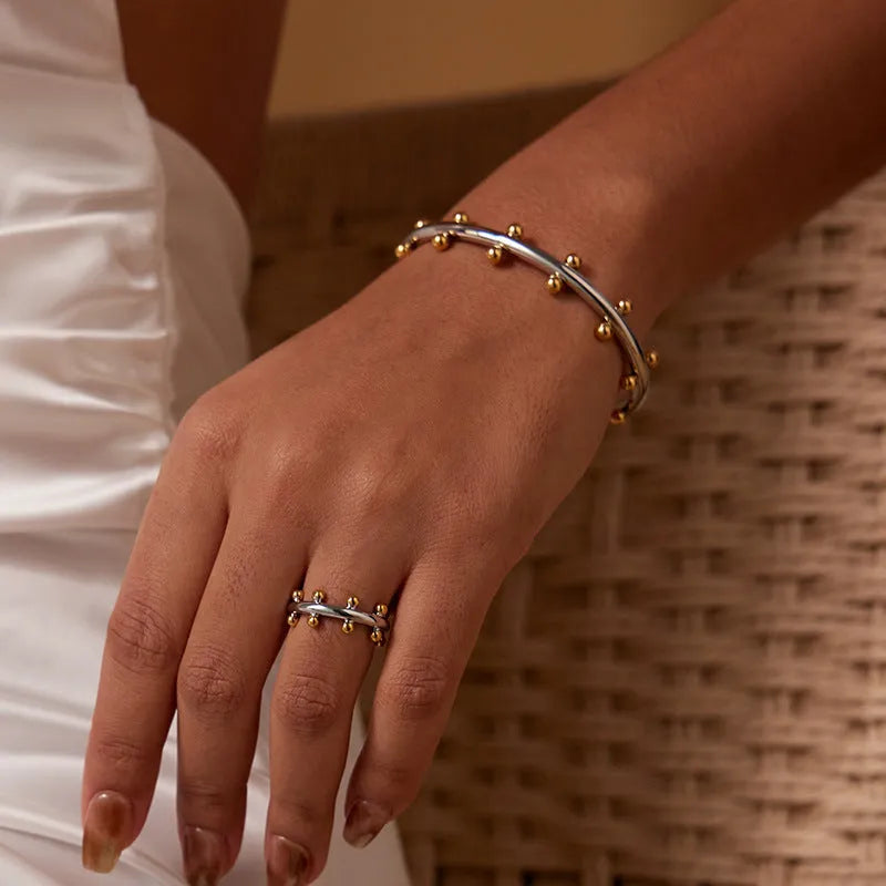 C-shaped textured rivet bean bead charm bracelet in gold, steel, or two-tone finish on an alloy chain.
