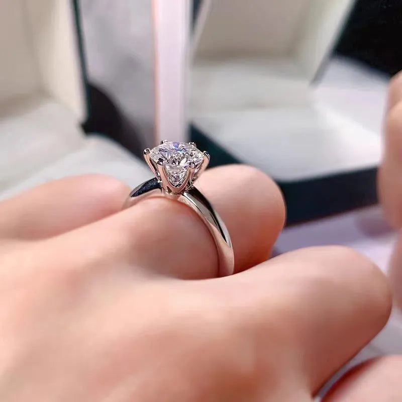 White gold-plated geometric ring with a six-claw setting holding a zircon stone.