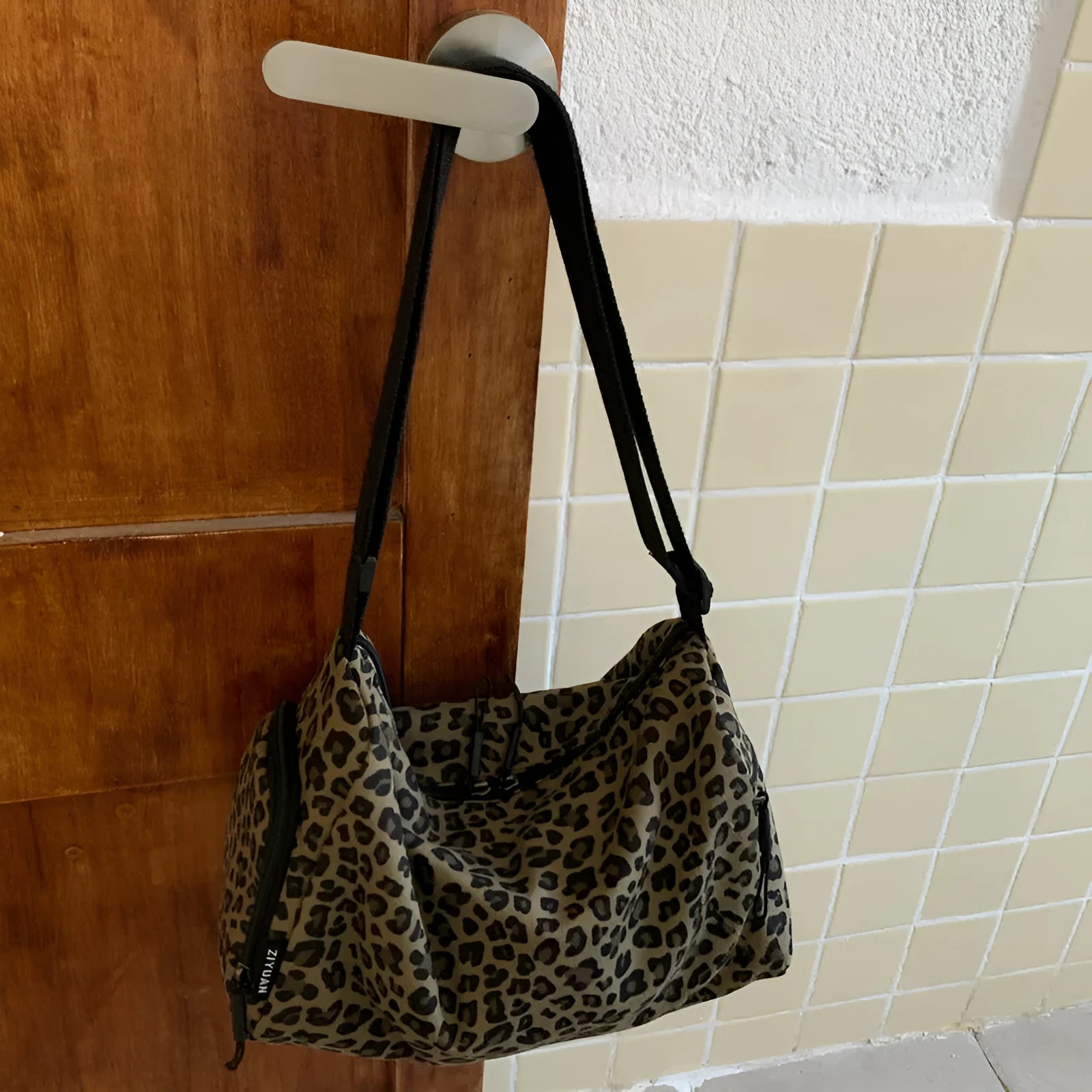 Sports style shoulder messenger bag in leopard print pattern with cross-body strap