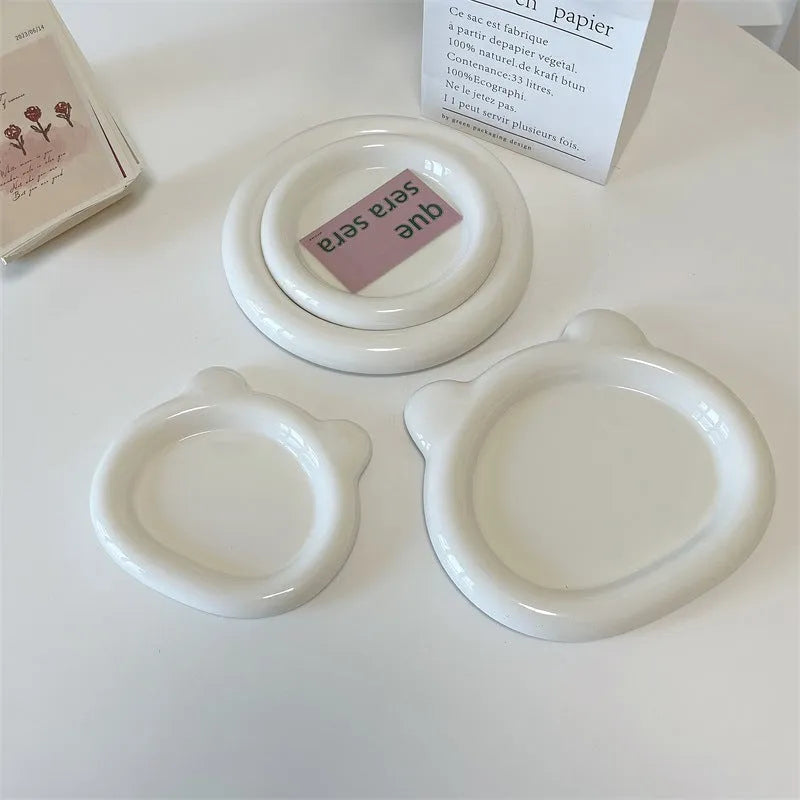 White porcelain round plate with chubby toot bear doodle pattern, shown as a plant saucer.