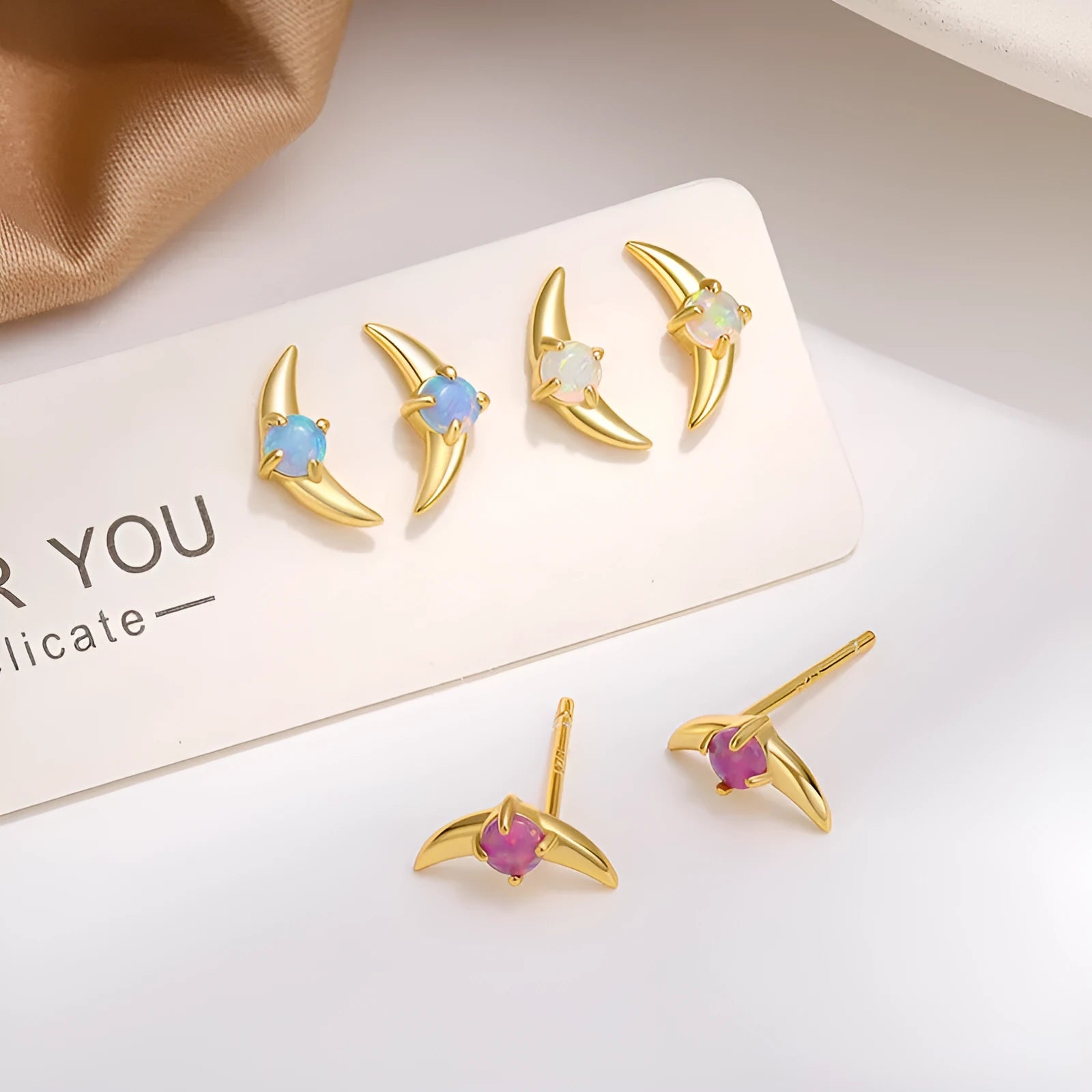 Geometric shaped 925 silver earrings with gold plating and a blue stone.