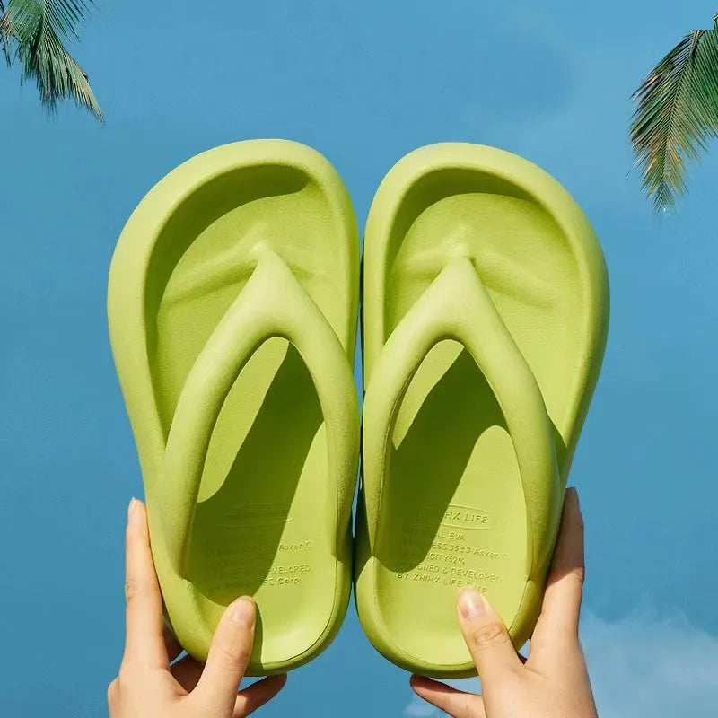 A pair of thick-soled flip-flops with a bow detail on the upper, shown in a solid colour.