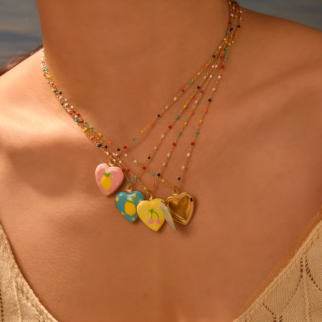 Stainless steel fruit pendant necklace with gold plating showing heart and fruit charm designs on adjustable chain