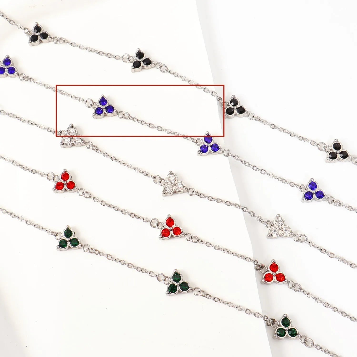 Women's stainless steel bracelet with a geometric triangle pendant, shown in gold and steel tone options with coloured stones.