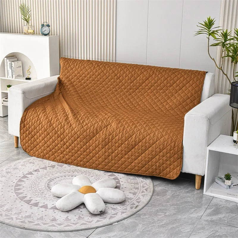 Reversible dog blanket showing two colours, laid flat on a sofa as a protective cover