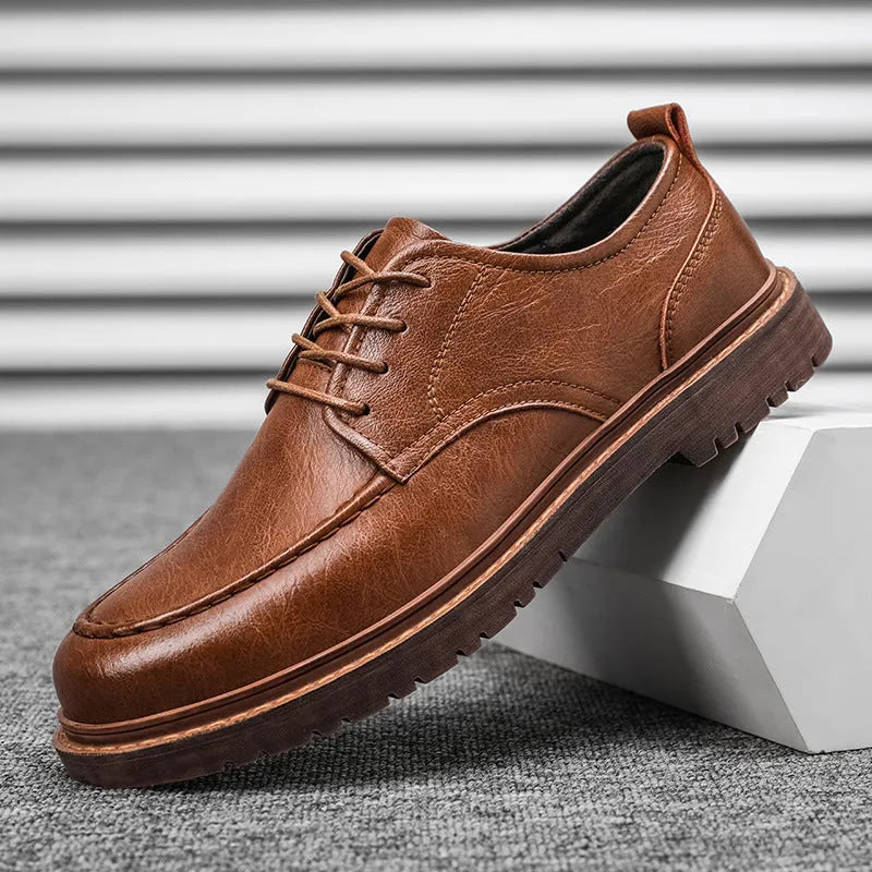 Men's black casual leather shoes with sewing line details and a round toe on a flat rubber sole.