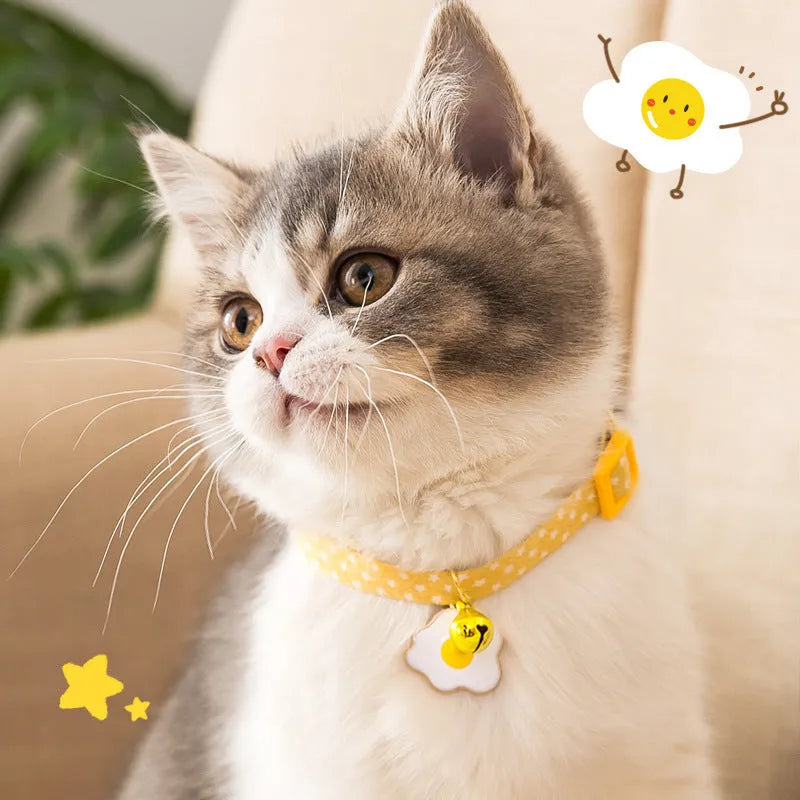 Green adjustable cat collar with a metal bell and pink bow tie on a small dog