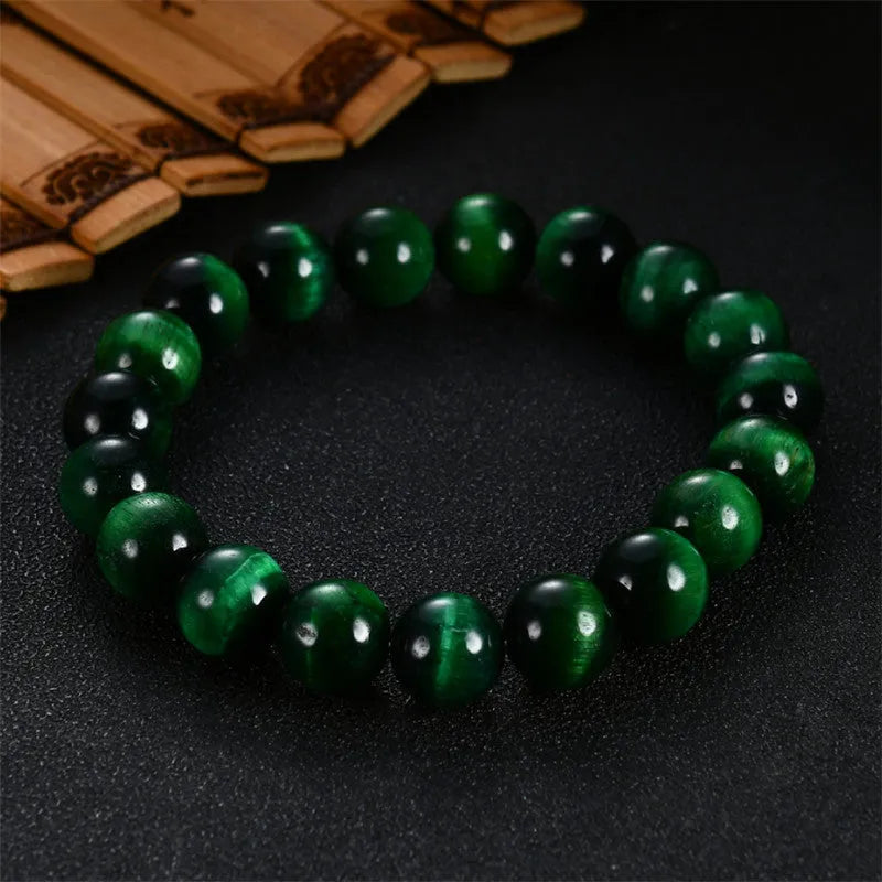 Green tiger eye stone geometric bead bracelet with adjustable closure on a wrist.