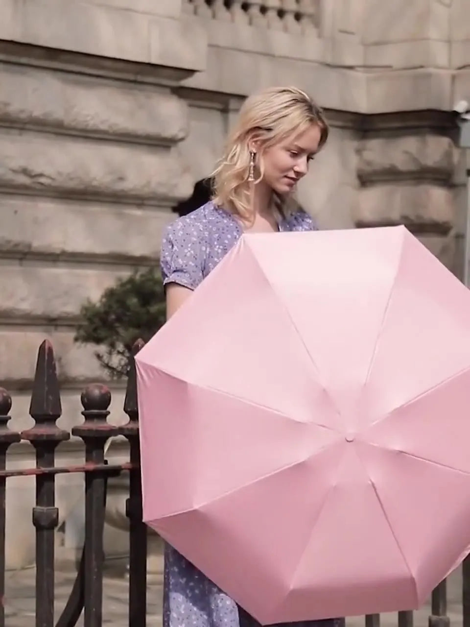 Ultra-light six-fold sun umbrella open, showing NC fabric canopy and rubber handle, next to its compact folded size in a capsule box.