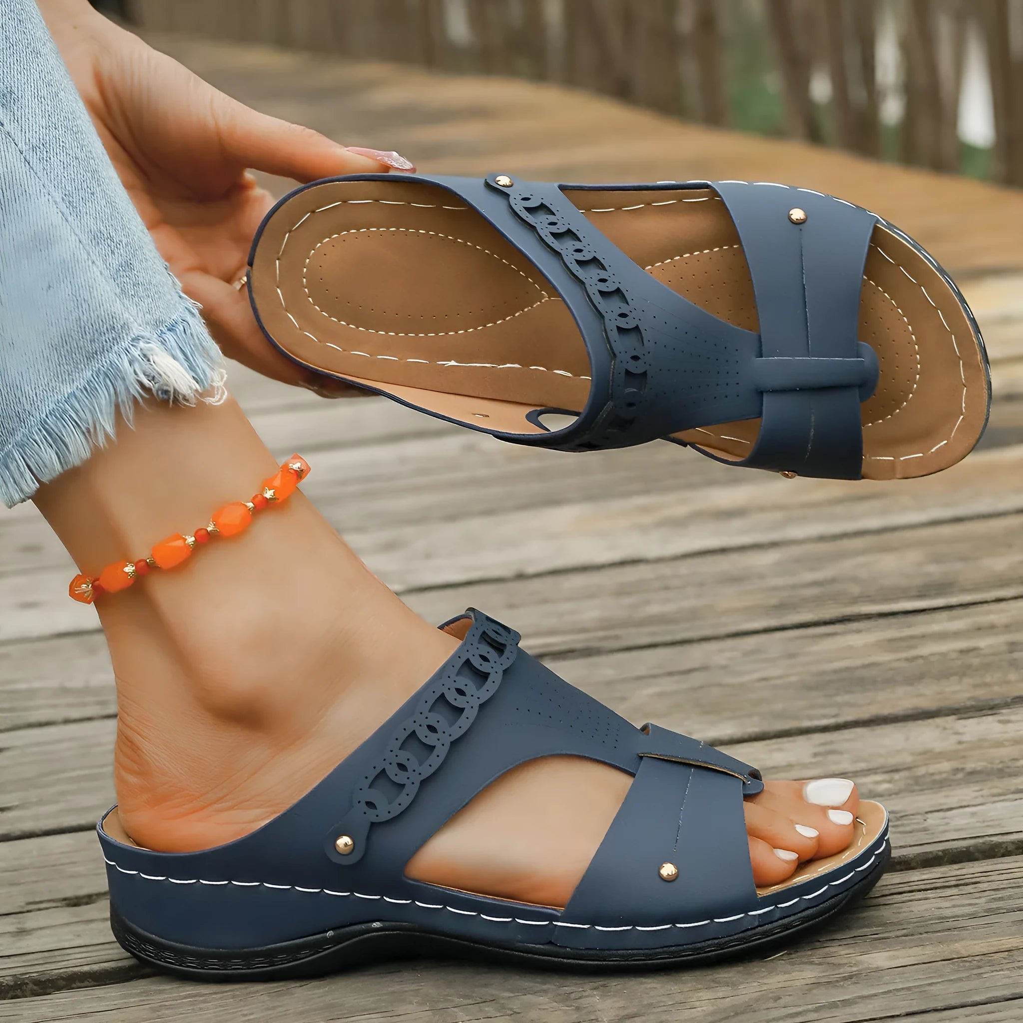 A pair of slope heel Roman style slippers with a fish mouth toe holder, shown in one of six available colours.