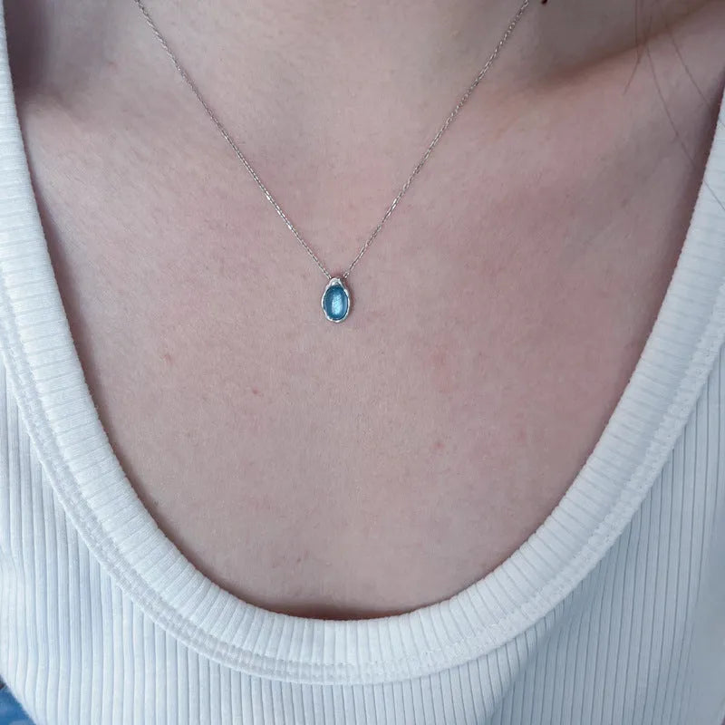 Navy blue water drop pendant necklace with geometric copper design on cross chain