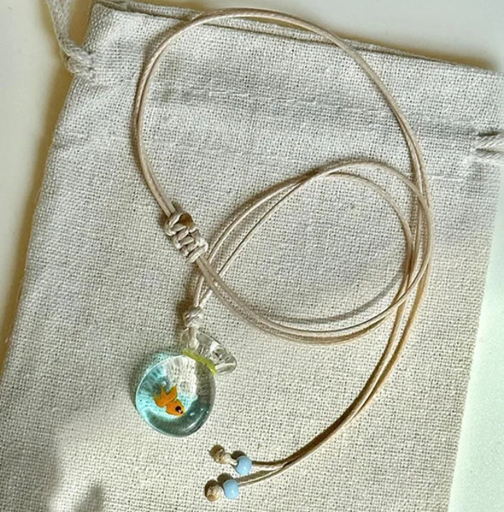 Women's necklace with a coloured glaze skirted joker pendant on a cotton and linen clavicle chain.
