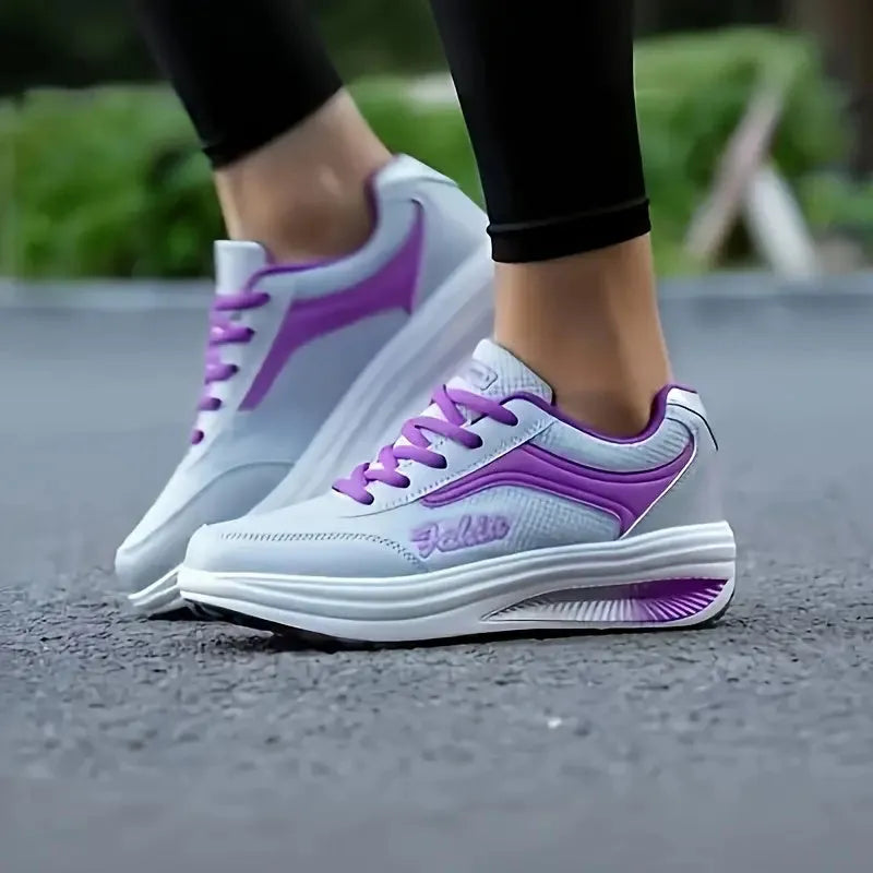 A pair of women's grey powder travel sports shoes with a mid-height heel on a white background.