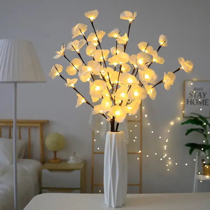 Pink Phalaenopsis orchid branch shaped LED decorative light on a table.