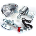 Silver aluminium bicycle dynamo light kit with generator, headlight, and tail light for friction-powered illumination.