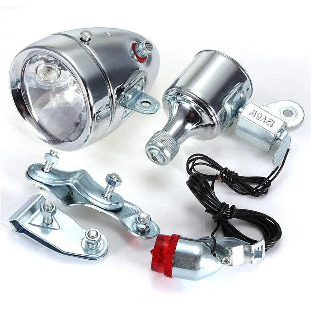 Silver aluminium bicycle dynamo light kit with generator, headlight, and tail light for friction-powered illumination.