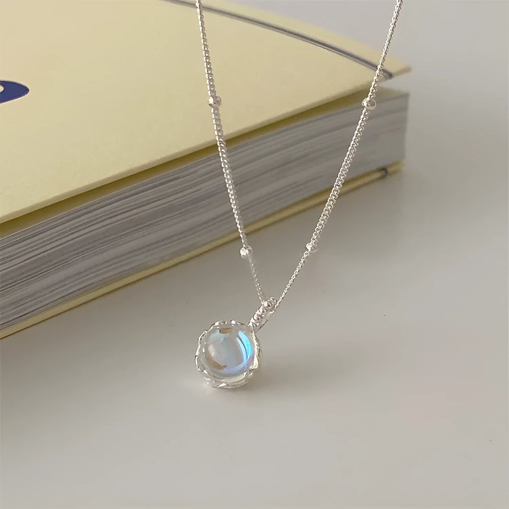 Women's silver ornamental stone necklace with geometric pendant on curb chain