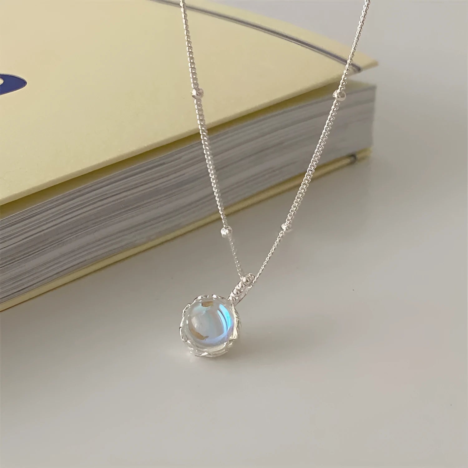 Women's silver ornamental stone necklace with geometric pendant on curb chain