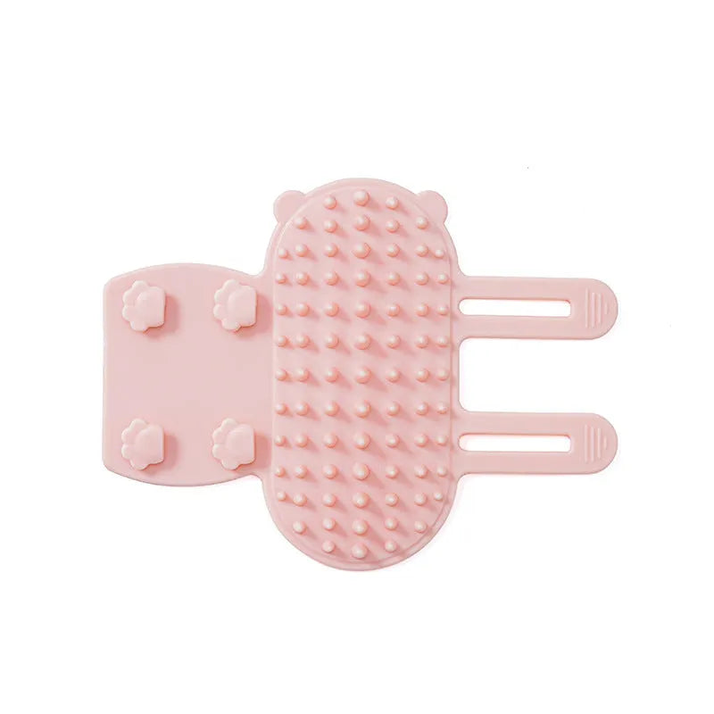 Silicone cat grooming comb with adjustable strap mounted on a table leg, shown in green colour.