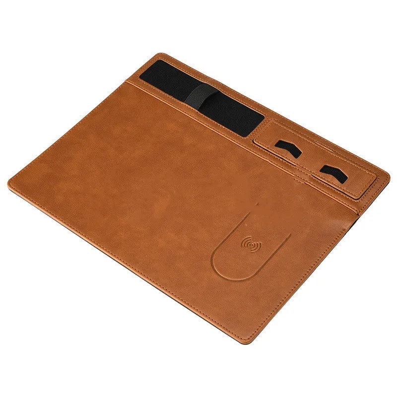 Large pink wireless charging mouse pad with integrated mobile phone holder on a desk.