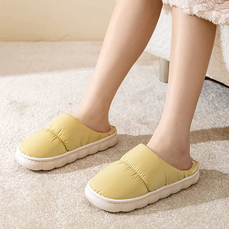 Pair of down cotton indoor slippers with artificial leather upper and thick rubber sole.